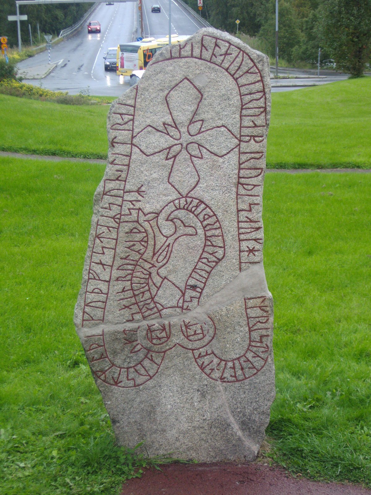 Der Frösö-Runenstein mit rot ausgemaltem Runenband und Kreuz