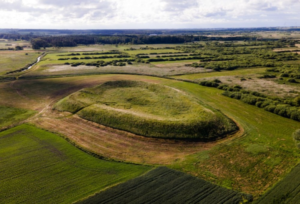 Luftaufnahme des Burgwalls von Czermno bei Tyszowce, ein grasbewachsener Ringwall in Feldern