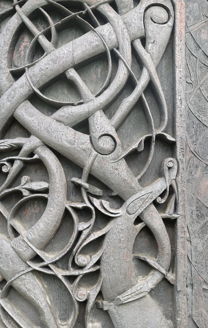 Animal-ornament carving on the north portal of Urnes stave church (Urnes style) — intertwined serpent and dragon bodies.