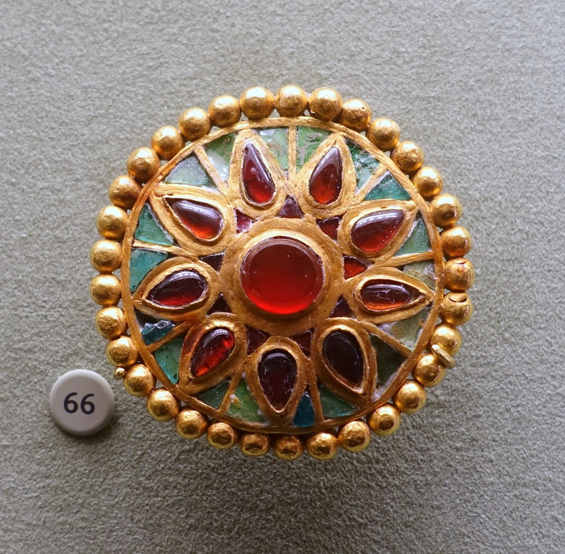 Scheibenfibel aus dem östlichen Schwarzmeerraum, um 450–500 n. Chr., Gold mit Granat- und Glaseinlagen (Cloisonné) — die Zellenschmelz-Technik, die noch die Völkerwanderungszeit prägte.